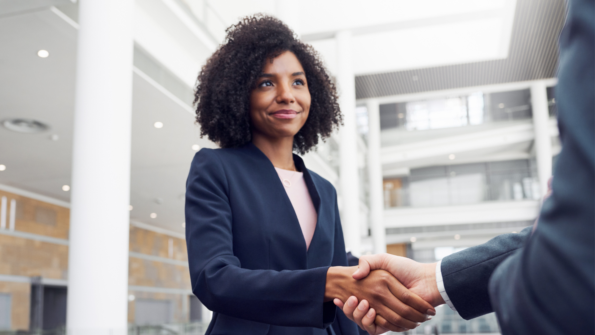 A recruiter shakes hands with the new hire.